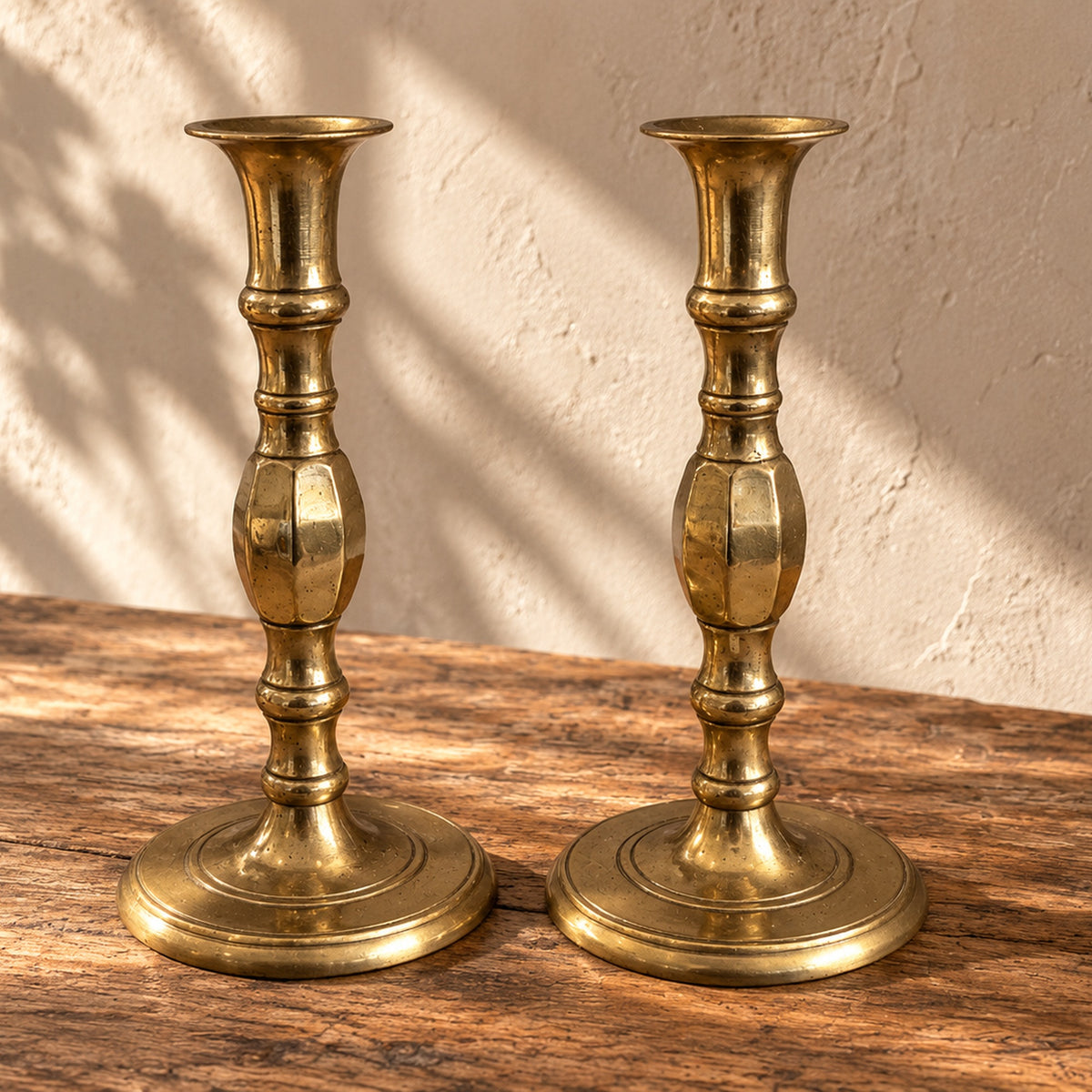 Pair of antique brass candlesticks on a wooden table